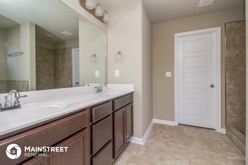the master bathroom has a large mirror and a large sink