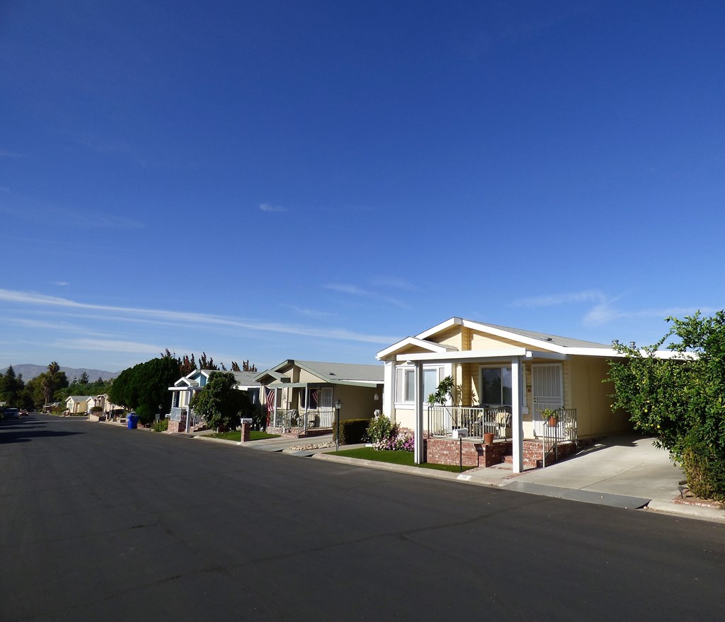 a row of houses on a street under a blue sky