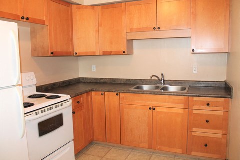 a kitchen with white appliances and wooden cabinets