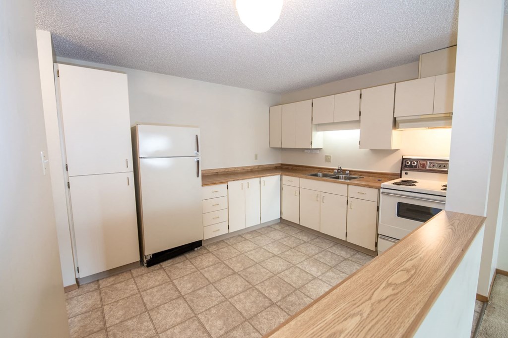 a kitchen with white cabinets and a stainless steel refrigerator