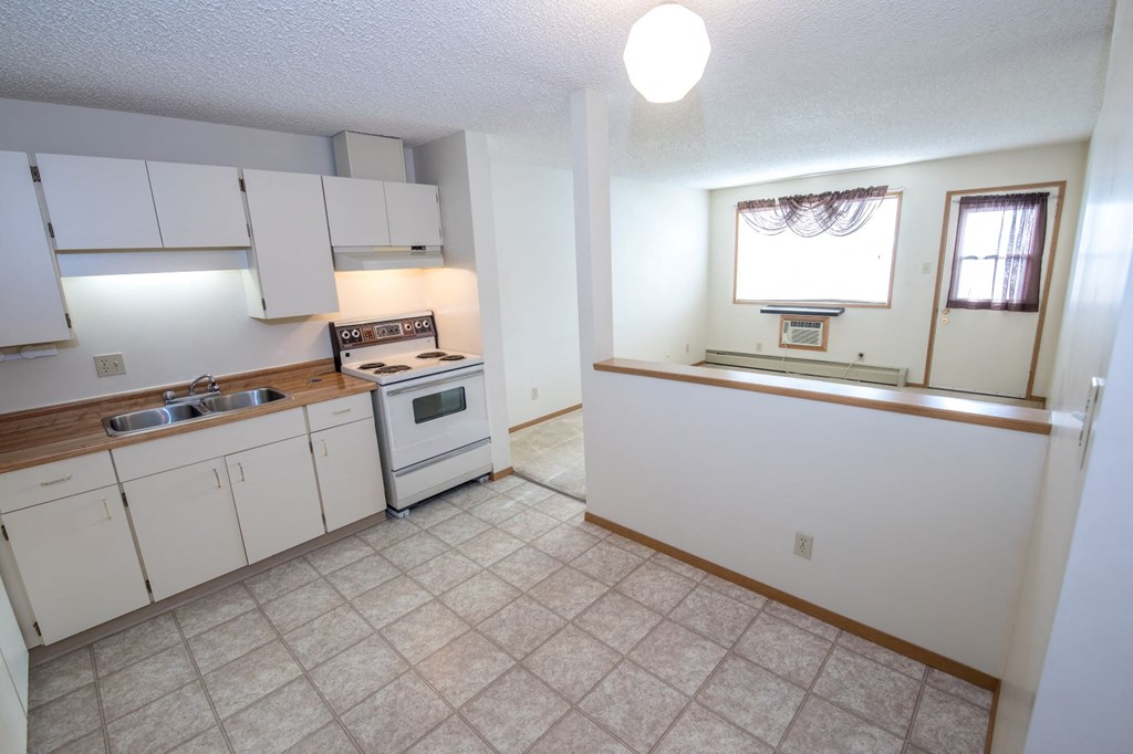 a kitchen with white cabinets and a stove and a sink