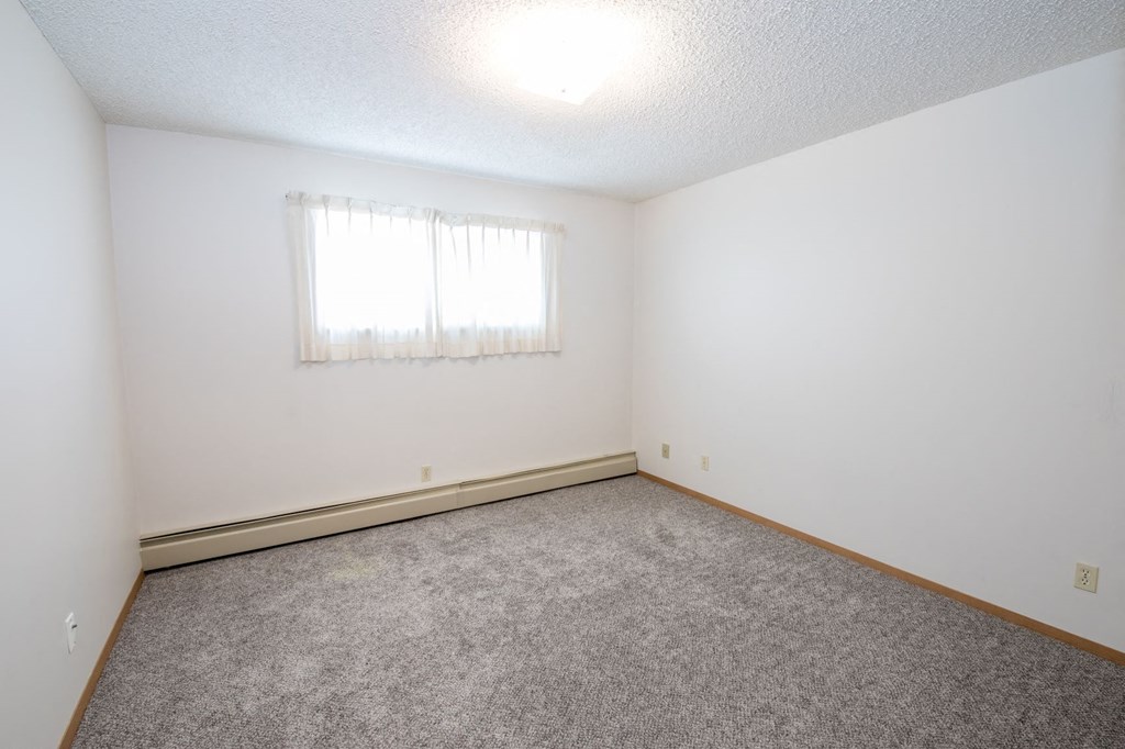 a empty room with carpet and a window