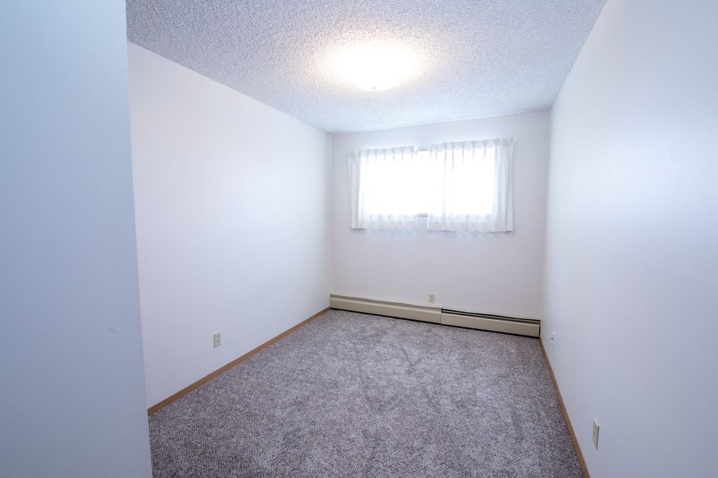 a empty room with carpet and a window