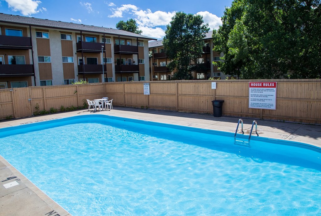 an empty swimming pool in front of an apartment building