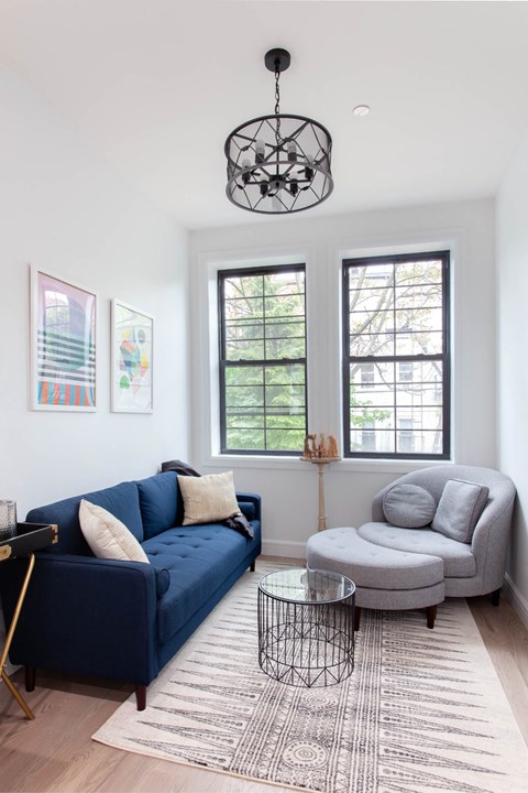 A living room with a blue couch and a grey armchair.