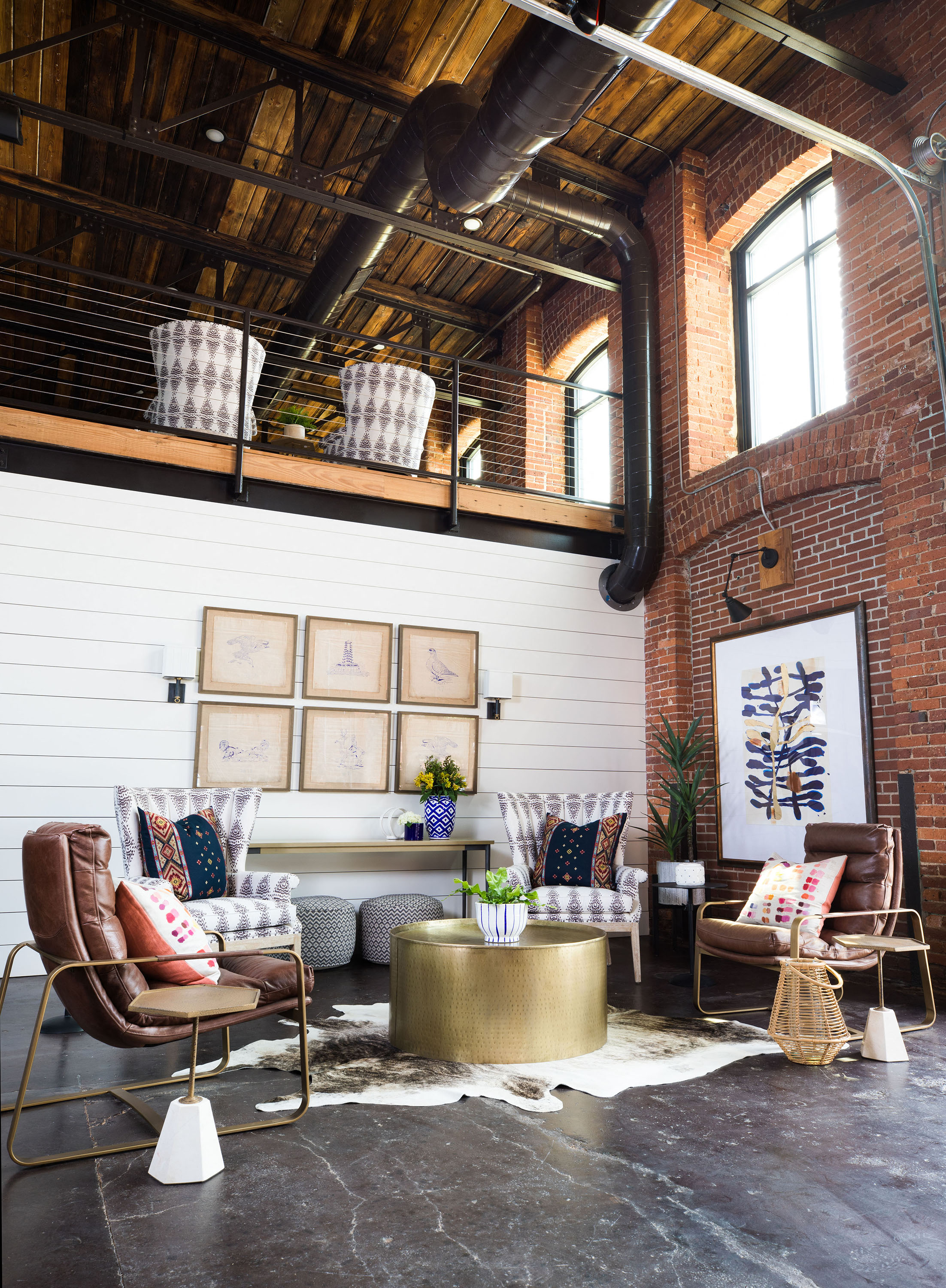 a living room with furniture and a exposed brick wall