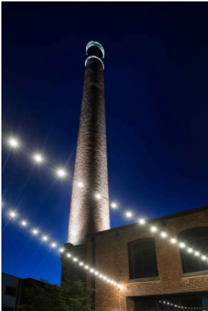 a fire pit in front of a brick building at night