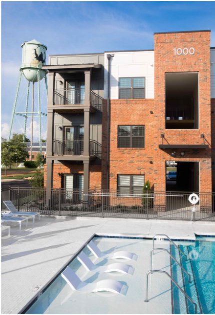 an apartment building with a pool and a water tower