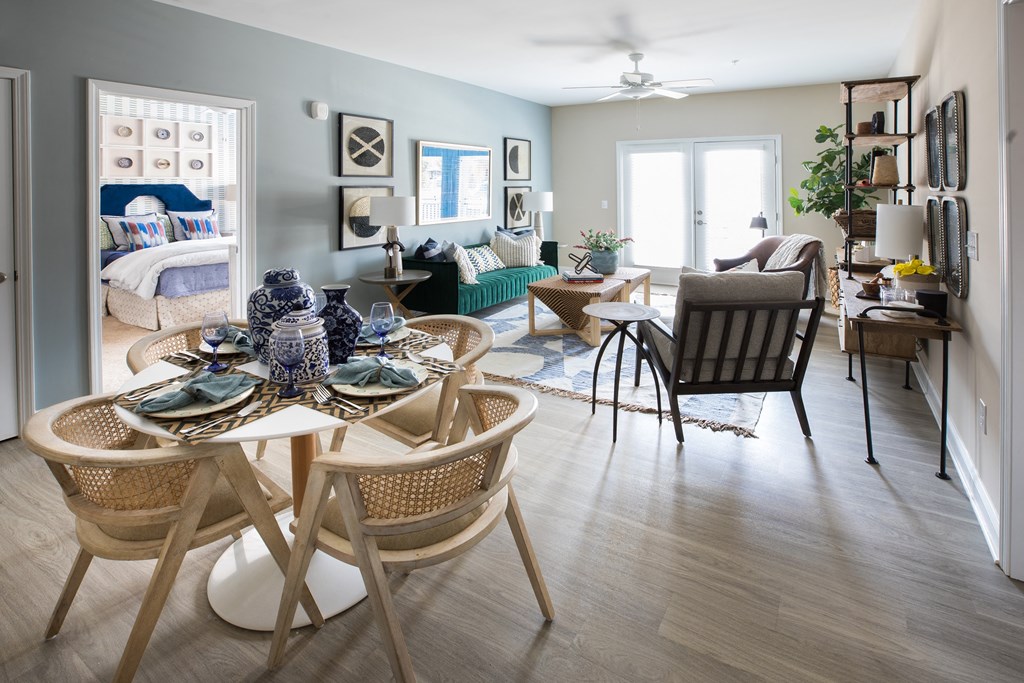 a living room and dining room with a table and chairs