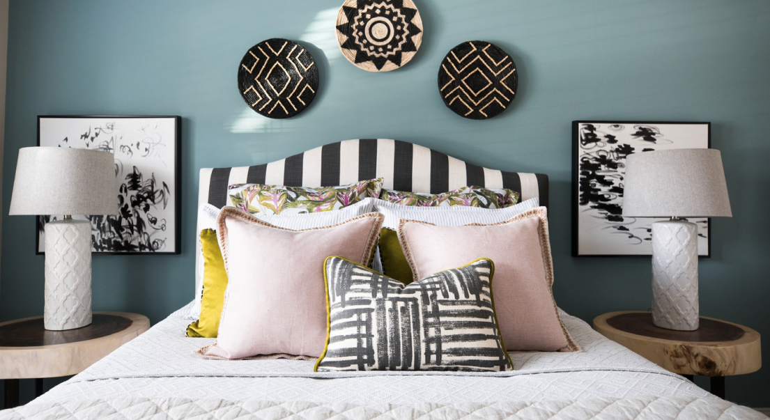 a bedroom with blue walls and pillows on the bed