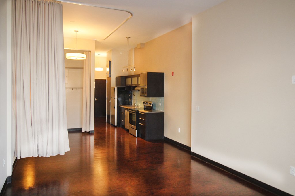 the living room and kitchen of an empty apartment