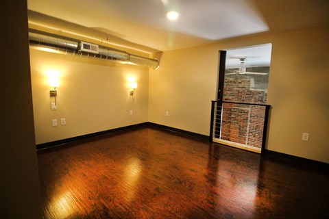 a empty living room with wood floors and a window