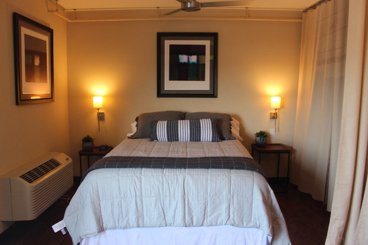 the master bedroom has a large bed and a window