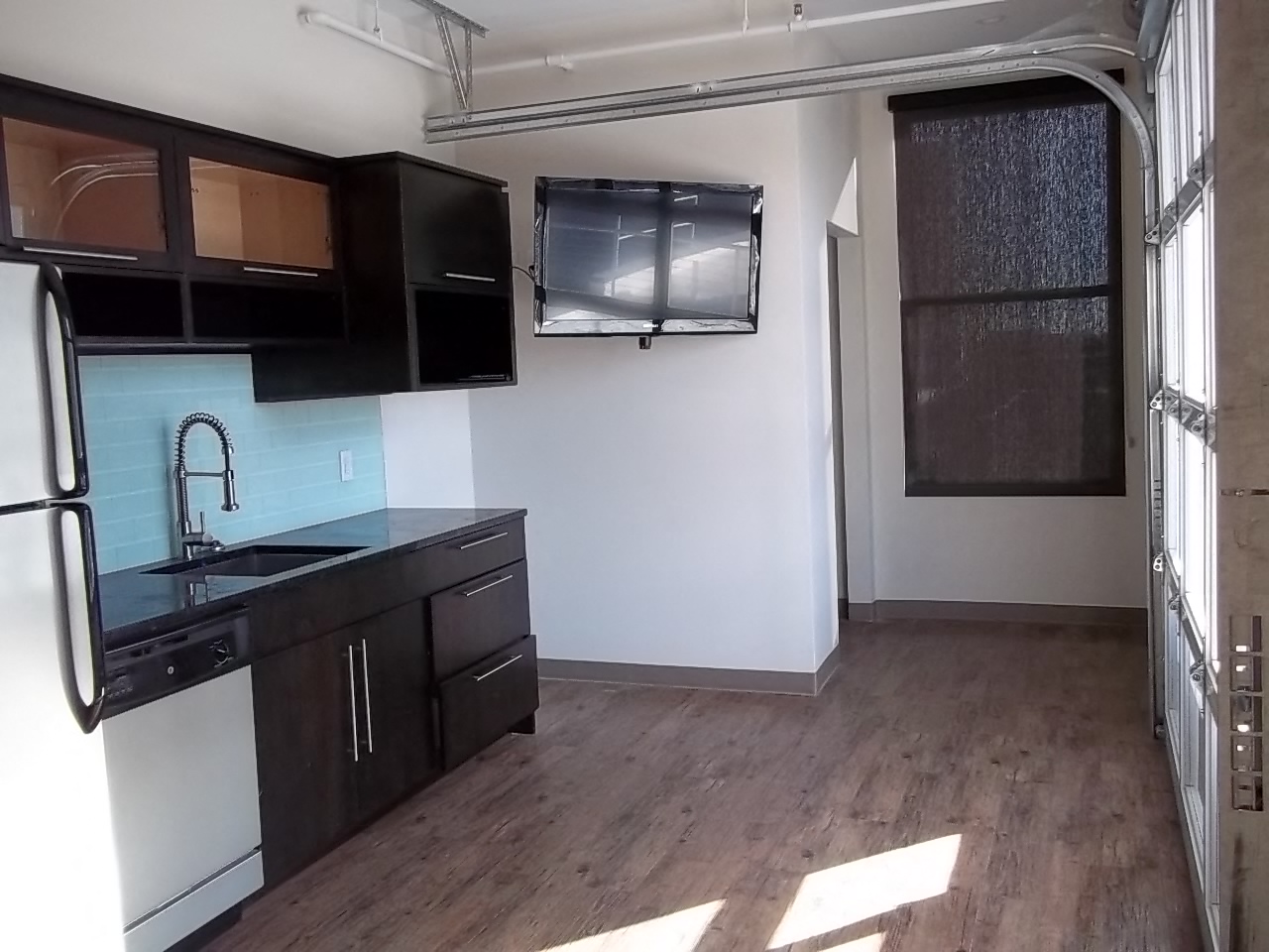 an empty room with a kitchen and a window