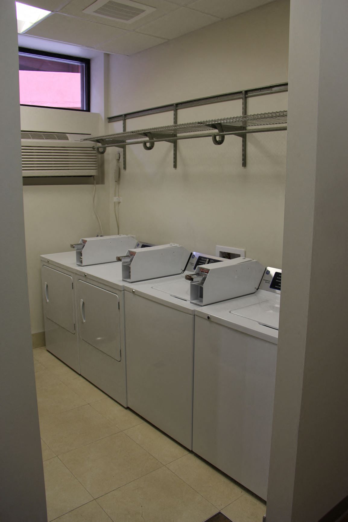 a row of washers and dryers in a laundry room