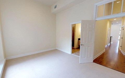 A large empty room with a doorway leading to another room.