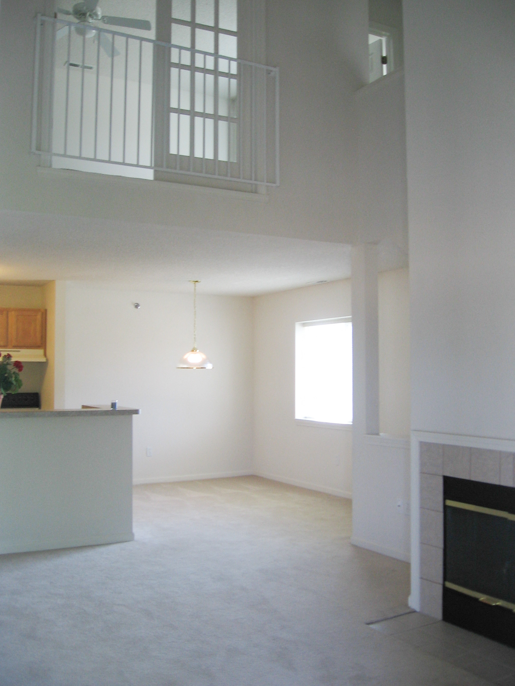 an empty living room with a fireplace and a window