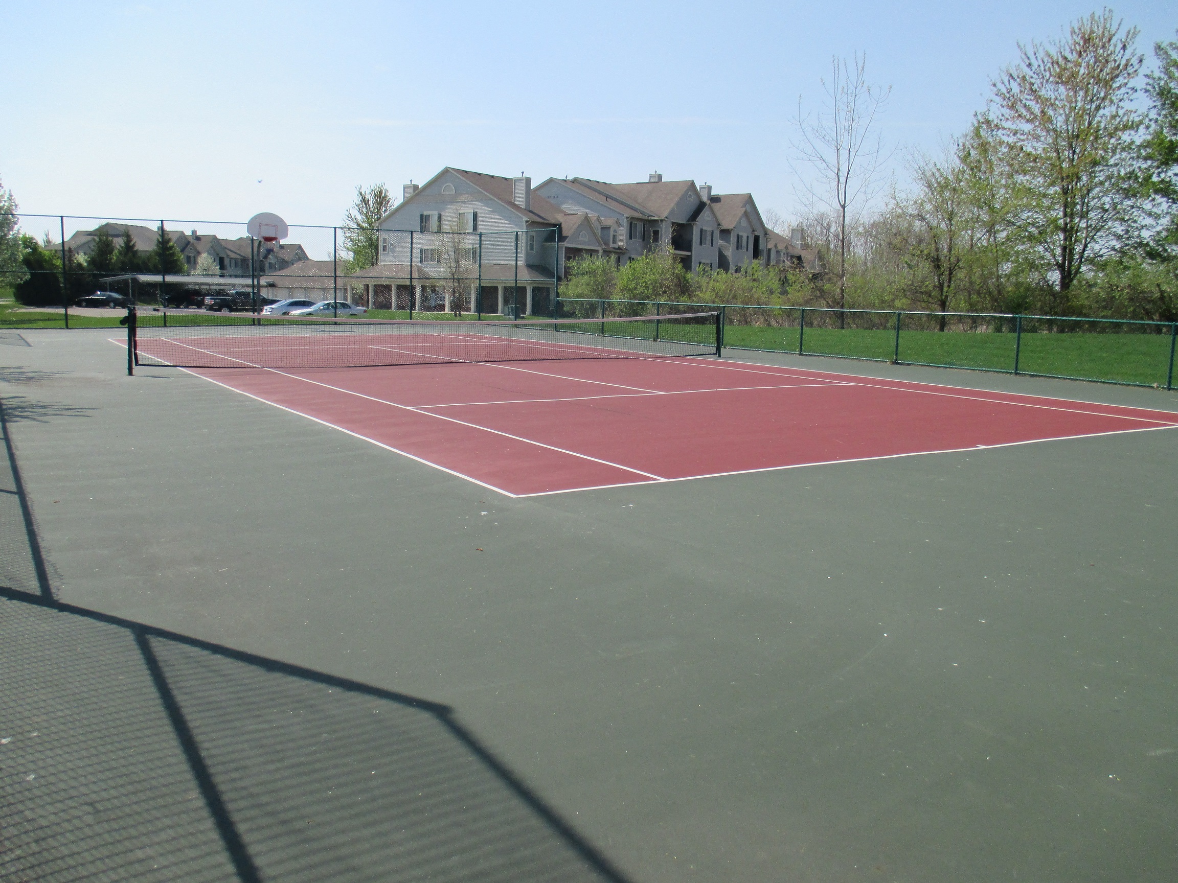 a tennis court with houses in the background
