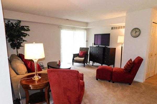 a living room with red chairs and a television