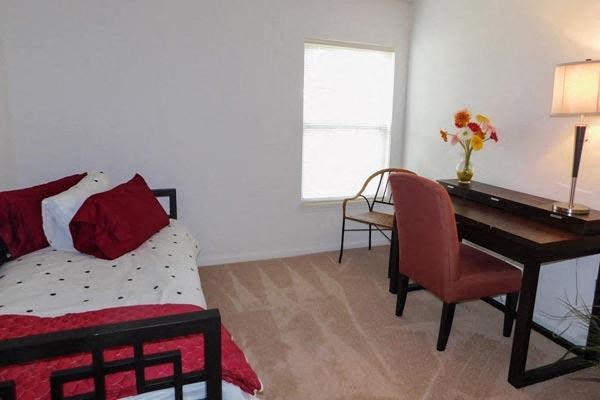 a bedroom with a bed and a desk with a chair