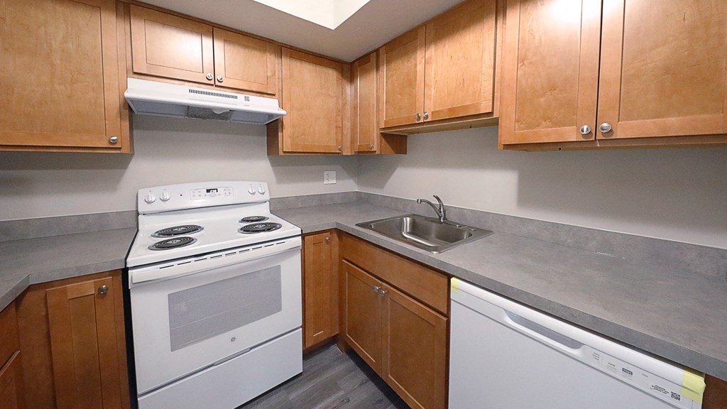 a kitchen with white appliances and wooden cabinets