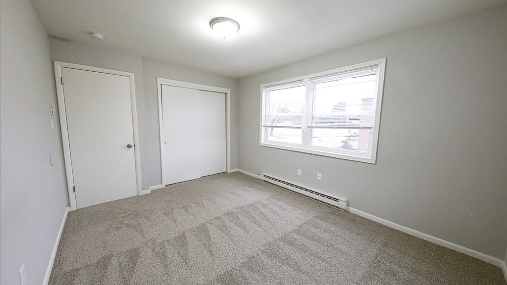 an empty room with carpet and a window