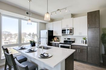 Kitchen with brown and white cabinets and large kitchen island with seating
