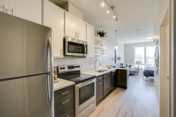 Wall of kitchen with two toned cabinets and stainless steel appliances