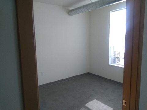 an empty room with a window and a carpet