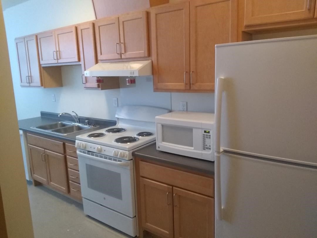 a kitchen with white appliances and wooden cabinets