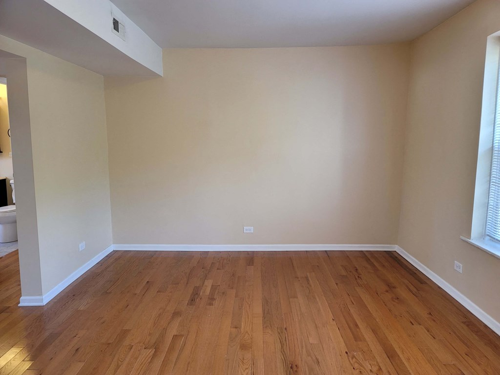 a empty living room with wooden floors and white walls