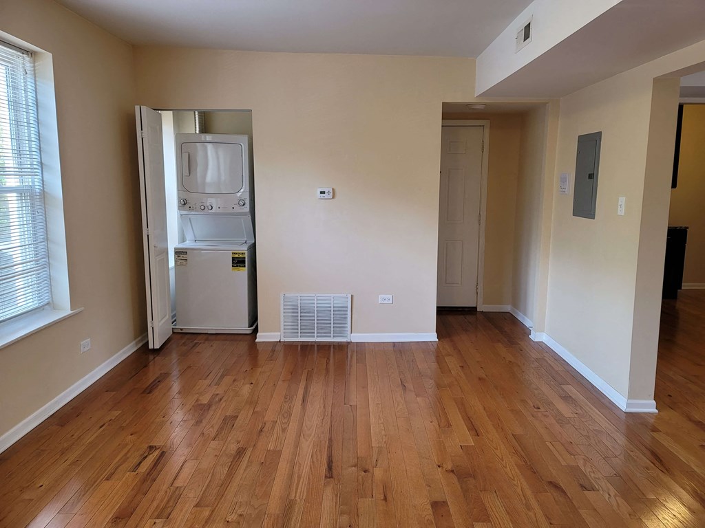a living room with a hard wood floor and a refrigerator