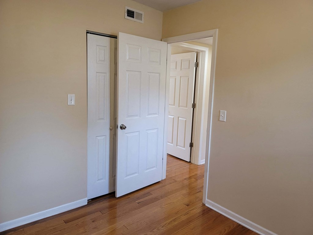 a bedroom with two closets and a door open to a hallway
