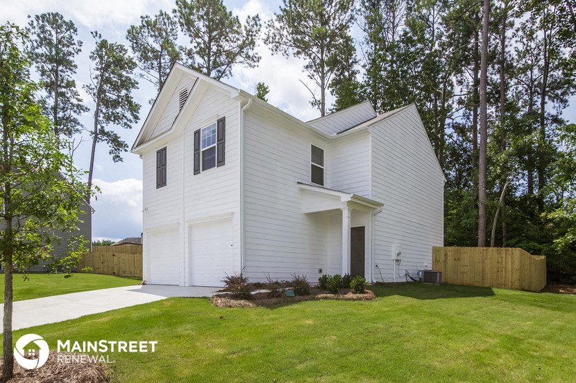 a white house with a lawn and trees