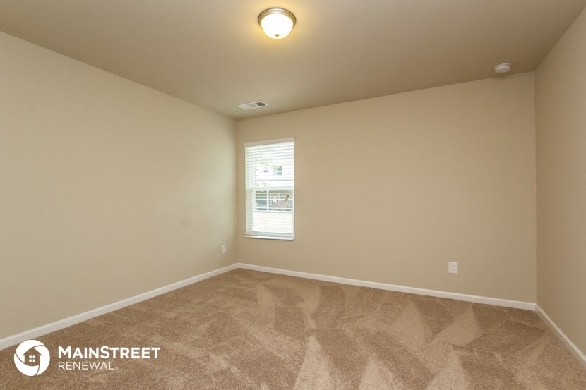 the upstairs bedroom with carpet and a window