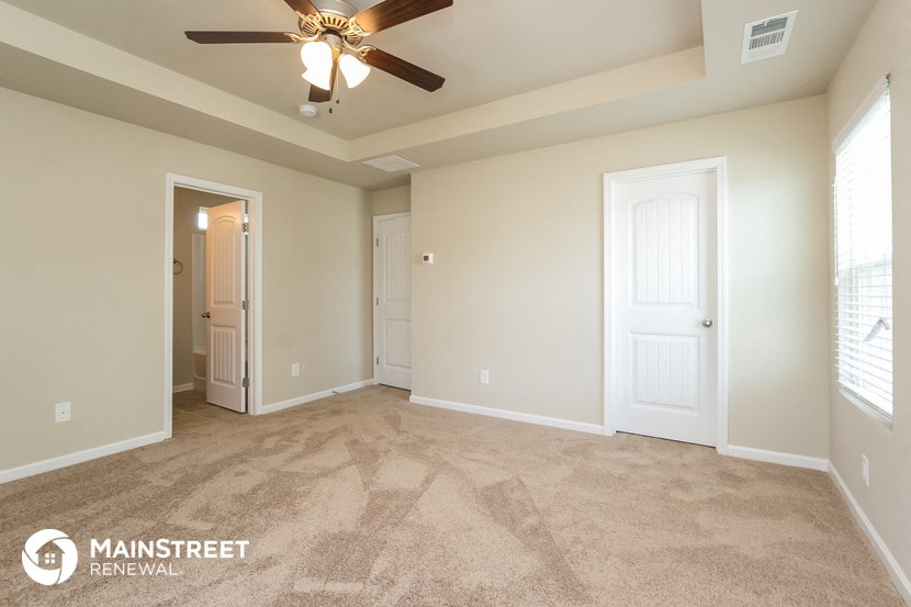 the master bedroom is spacious and has a ceiling fan