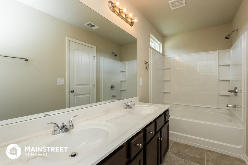 a bathroom with a sink and a tub and a mirror