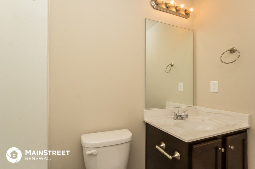 a bathroom with a toilet and a sink and a mirror