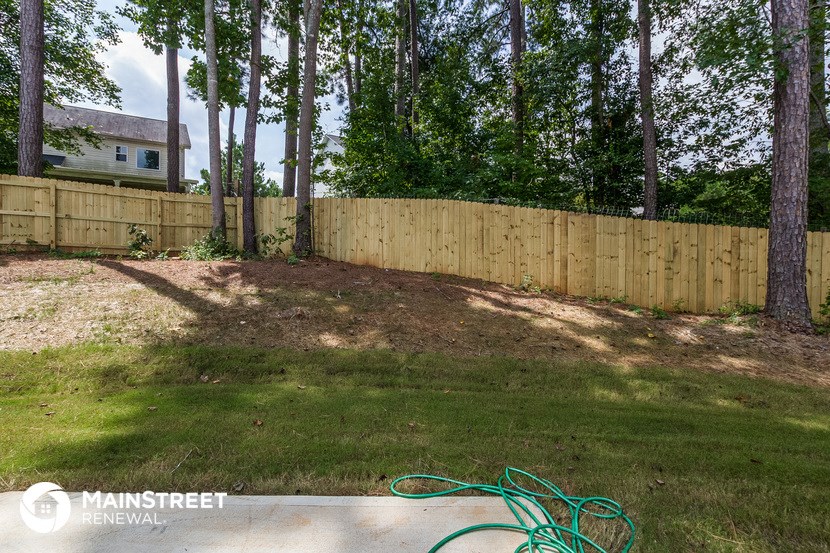 the backyard of a home with a wooden fence