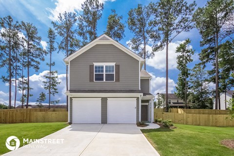 a gray house with a garage and a lawn