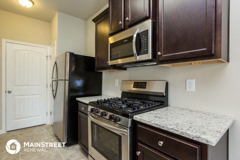the kitchen has stainless steel appliances and a granite counter top