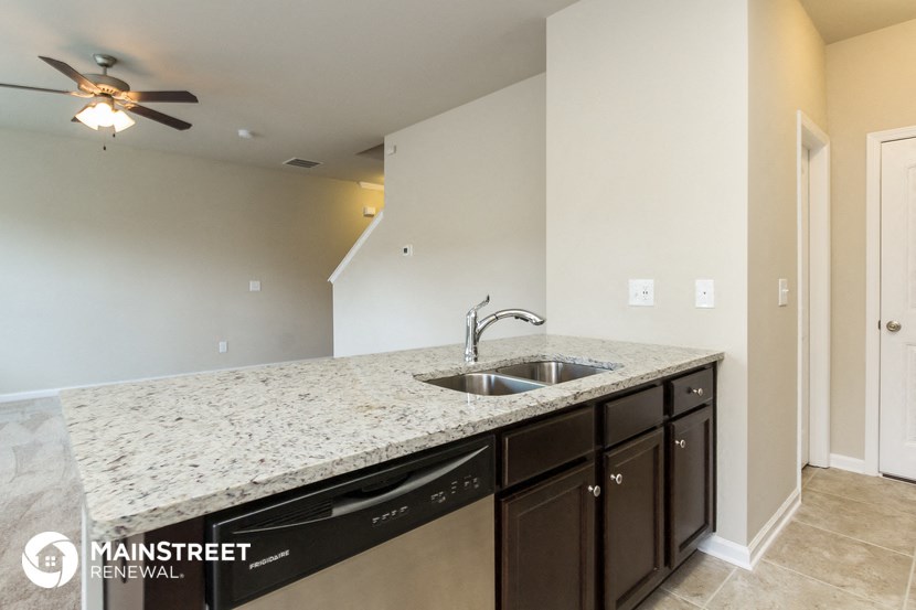 the kitchen has granite counter tops and stainless steel appliances