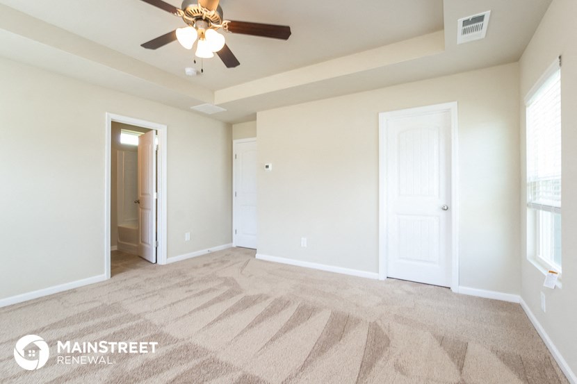 a living room with carpet and a ceiling fan