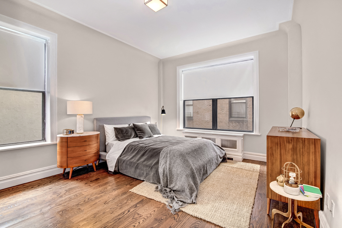 a bedroom with a bed and two windows