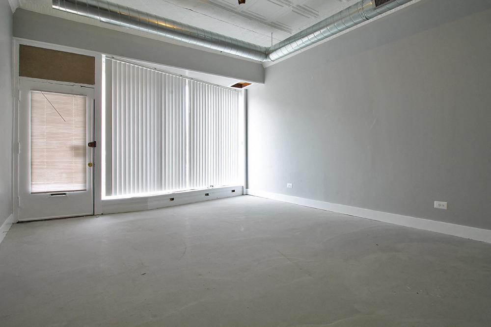 an empty living room with white walls and a door