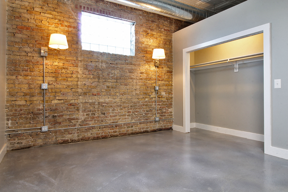an empty room with a brick wall and a garage door