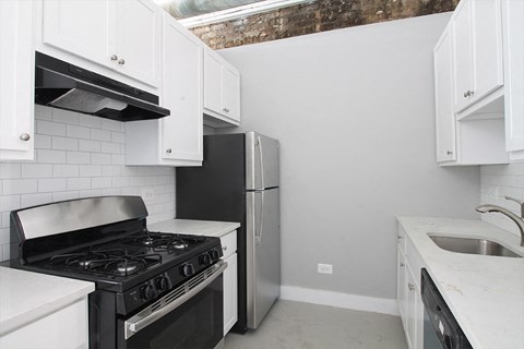 a kitchen with white cabinets and a black stove and a refrigerator