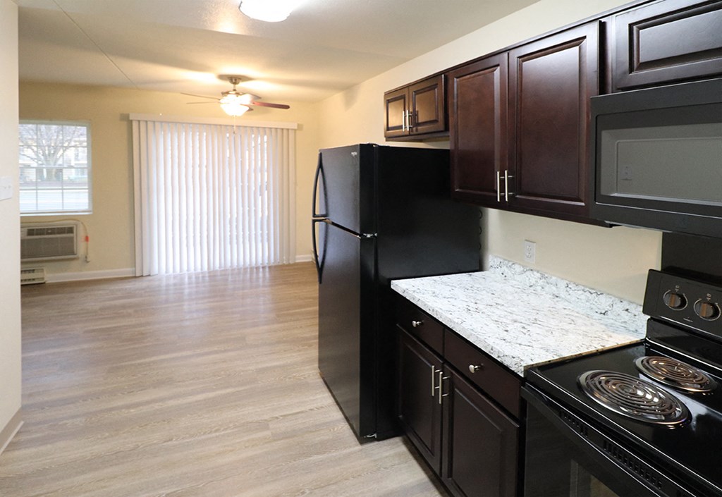 a kitchen with black appliances and a counter top in an empty room