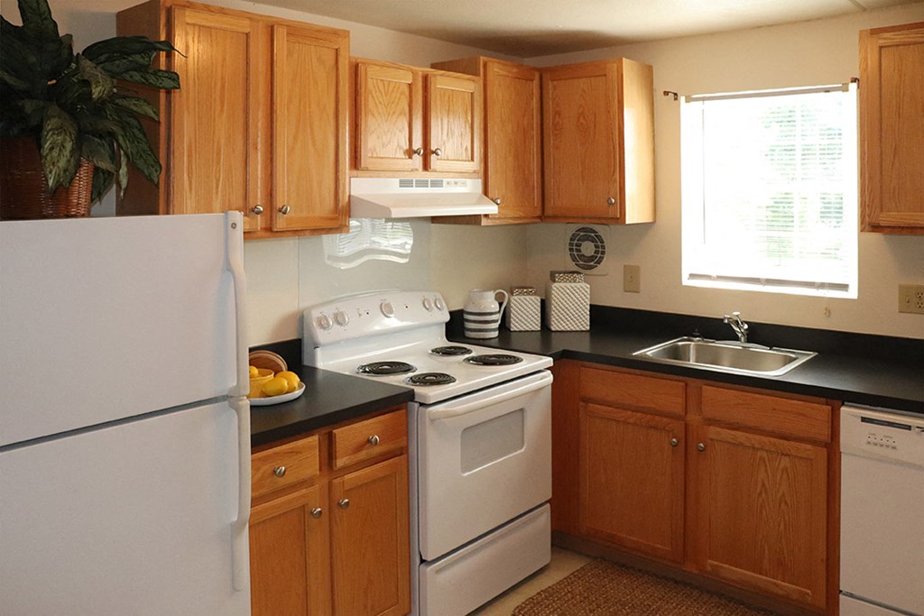 a kitchen with white appliances and wooden cabinets