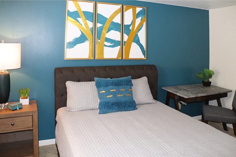 a bedroom with blue walls and a bed with pillows